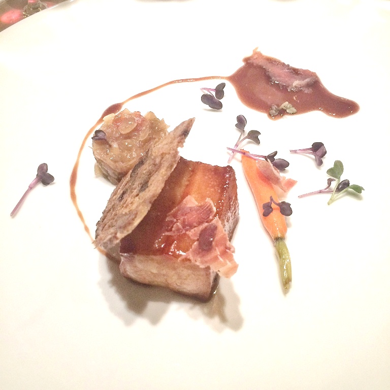Organic farm pork belly cooked in low temperature served with tomato confit and caramelized vegetables
